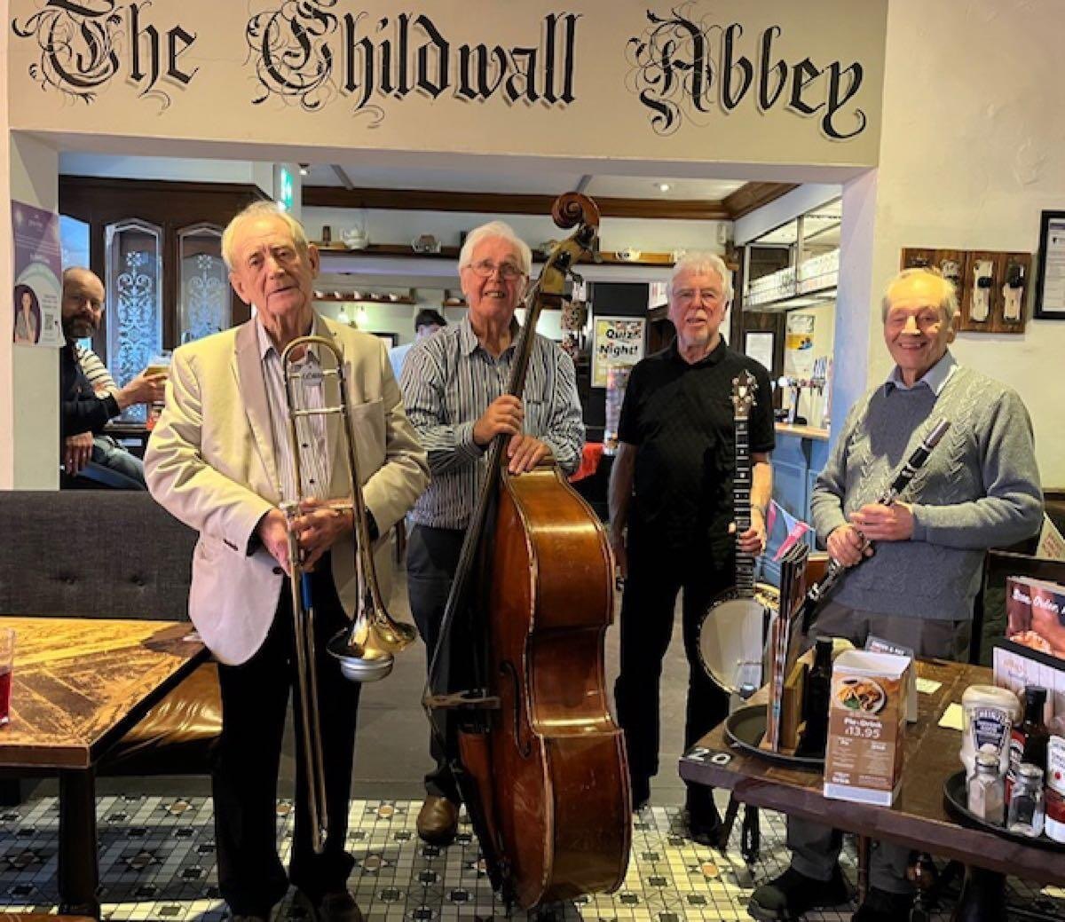 Picture of four gentlemen holding different musical instrument